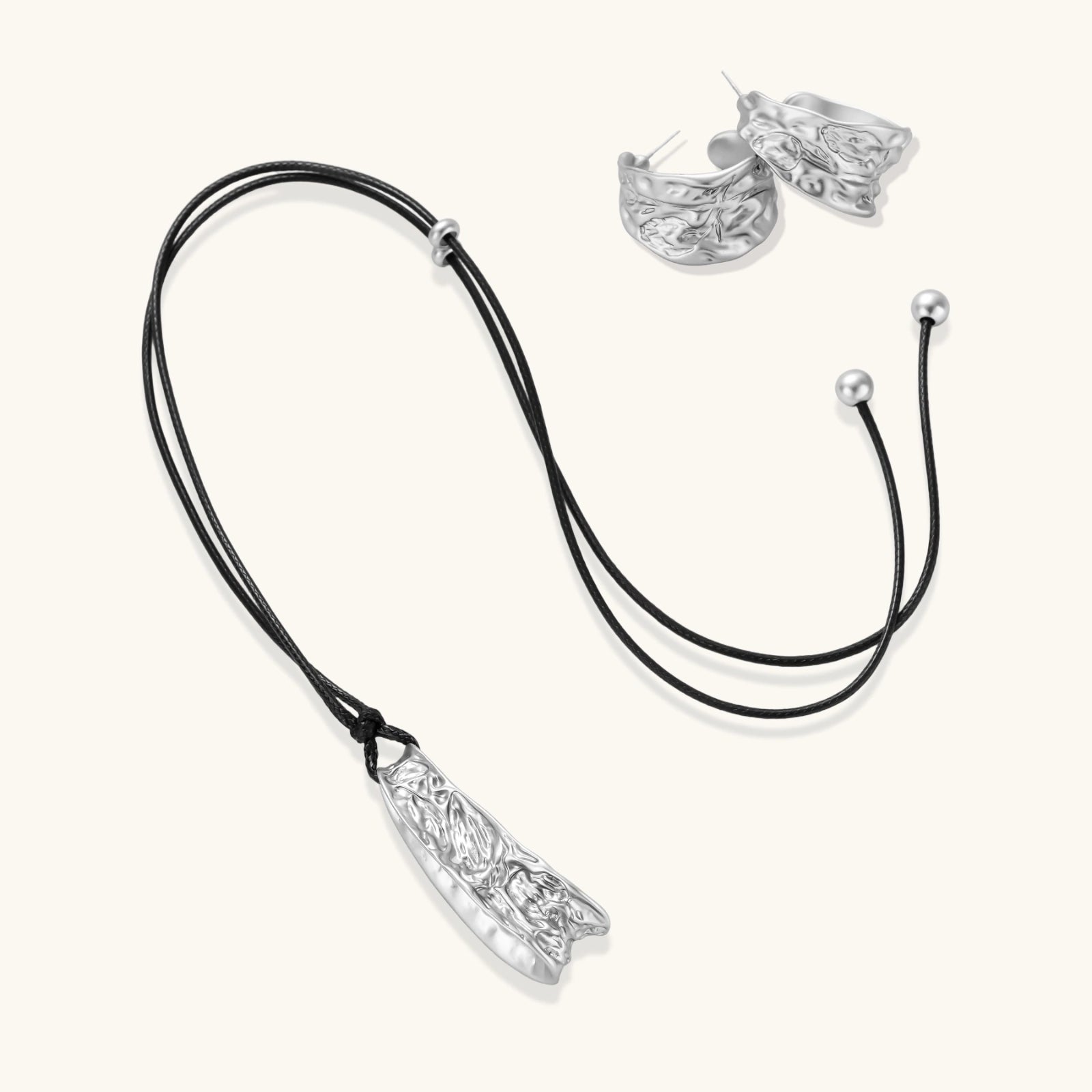 Textured silver jewelry set with floral engravings featuring adjustable cord necklace and matching hoop earrings